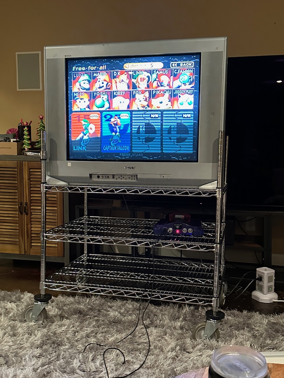 Wire rack rolling cart with a 32" Sony Wega TV and a grape N64